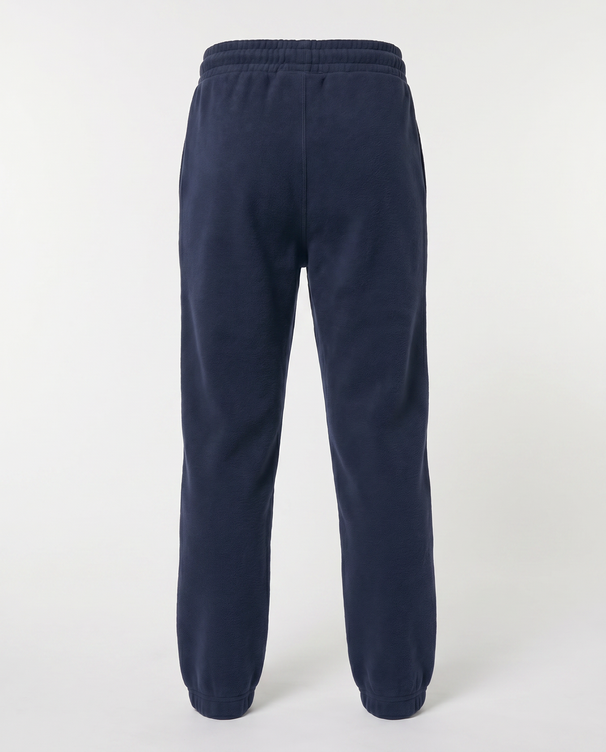 A pair of navy blue sweatpants shown from the back, featuring an elastic waistband and ribbed ankle cuffs, photographed against a light gray studio background.