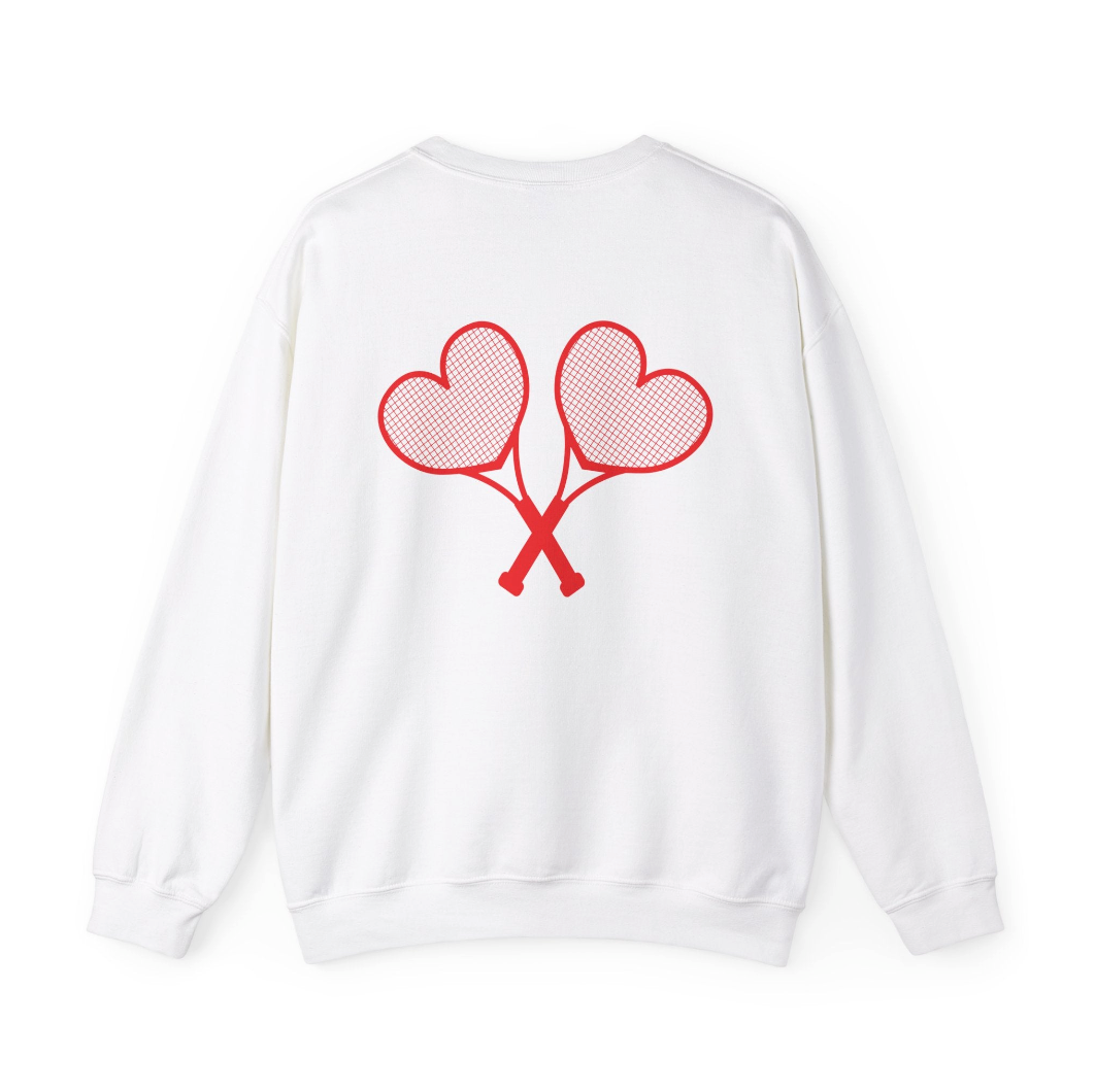 A white sweatshirt with red heart tennis rackets crossed on the back set against a white background
