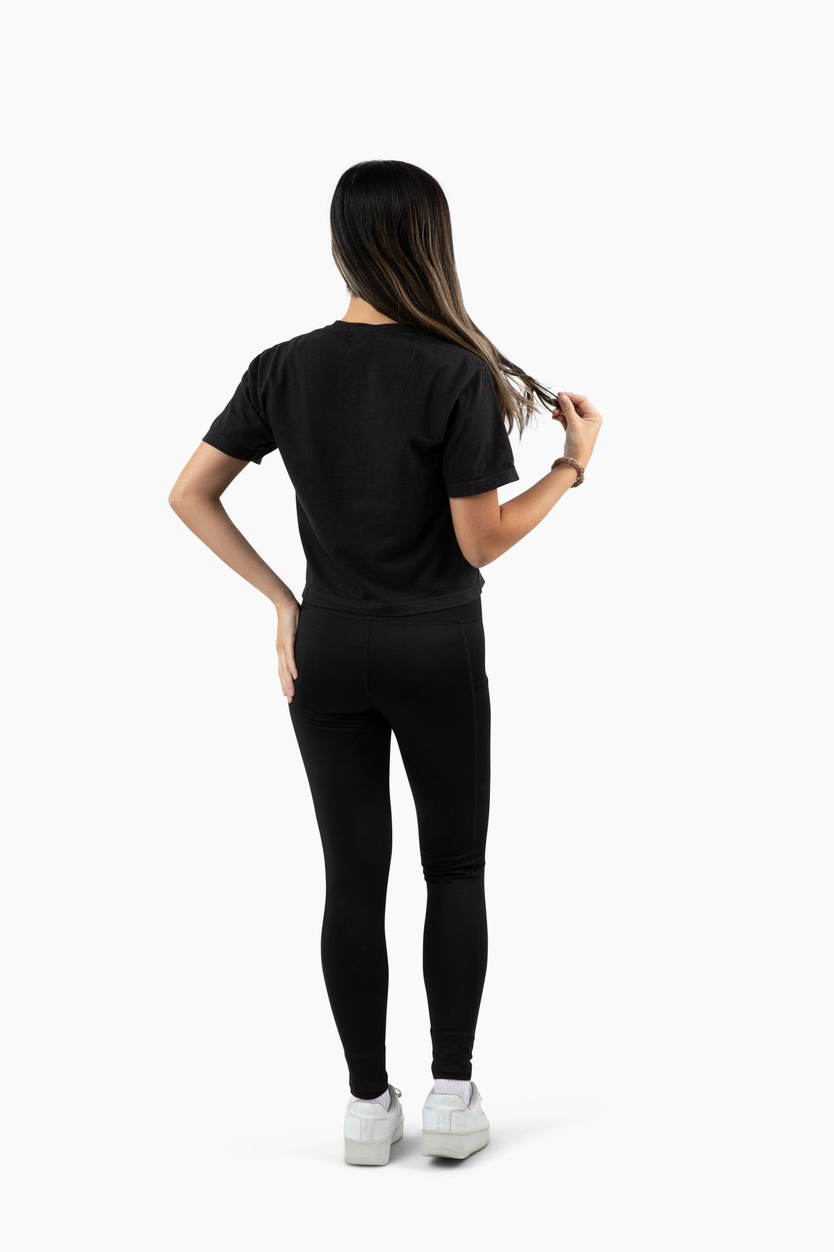 Person wearing a black t-shirt and leggings set on a white background