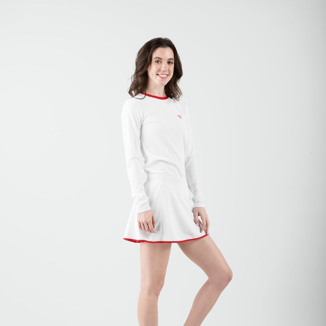 Woman in white and red tennis outfit on gray background