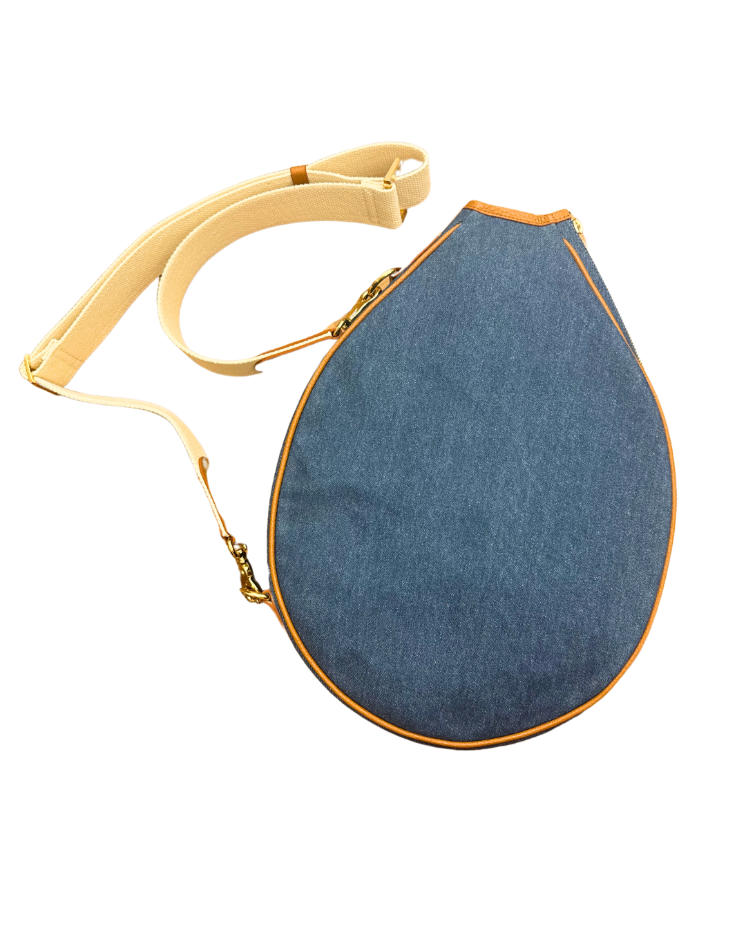 A denim teardrop-shaped shoulder bag with a cream-colored adjustable strap and gold-tone hardware, shown on a plain white background.