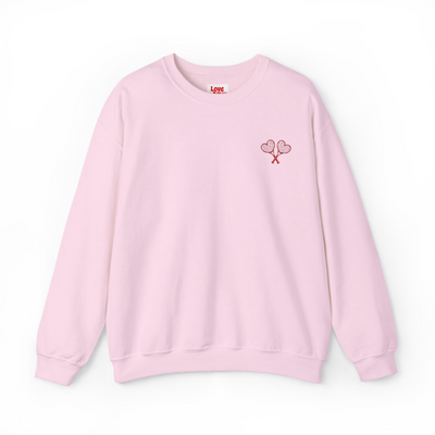 Pink sweatshirt with a small design on the chest against a white background