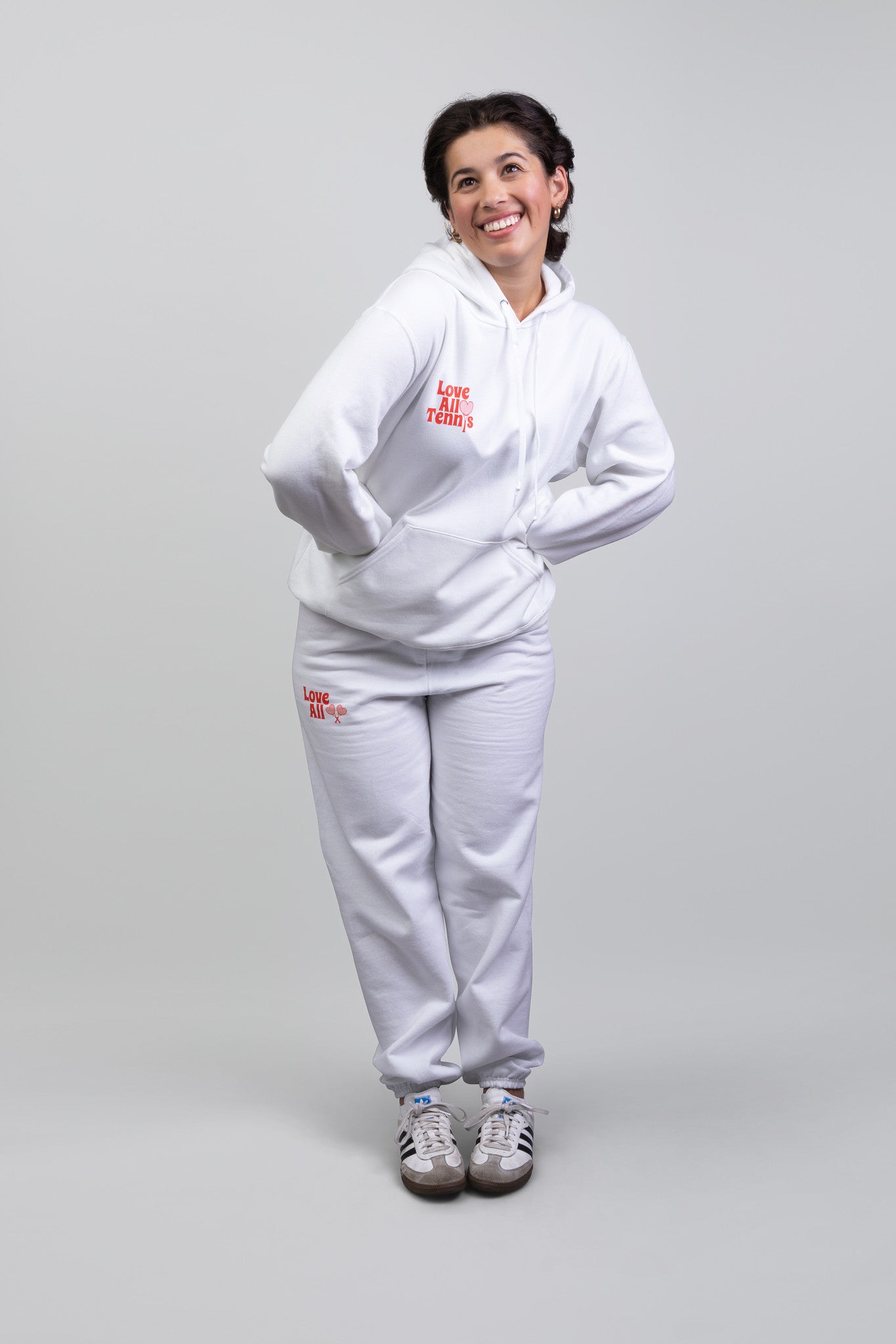 Person wearing a white tracksuit with red text on a gray background