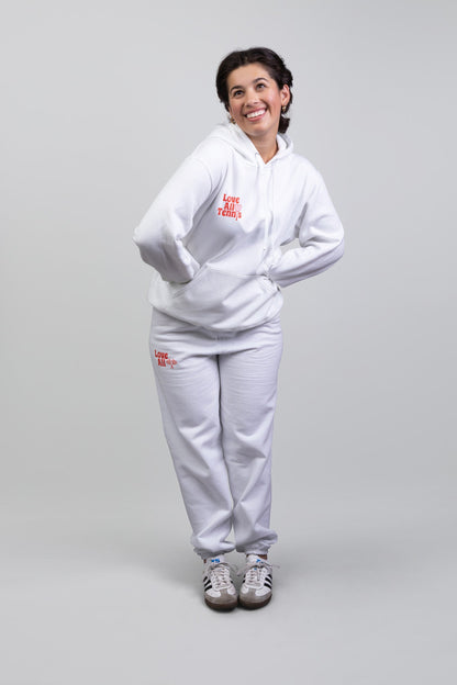 Person wearing a white tracksuit with red text on a gray background