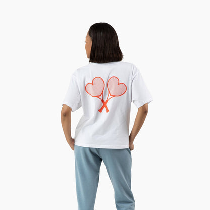 Person wearing a white t-shirt with a heart design on the back, standing against a white background.