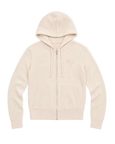A cream-colored zip-up hoodie with a drawstring hood, kangaroo pockets, and a small tonal embroidered logo on the left chest, displayed against a solid white background.