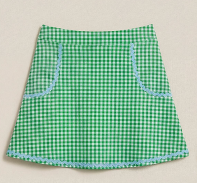 Green gingham skirt with blue trim on a beige background