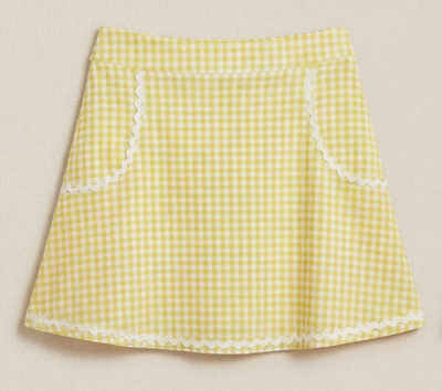 Yellow and white gingham skirt with white trim shown on a beige background