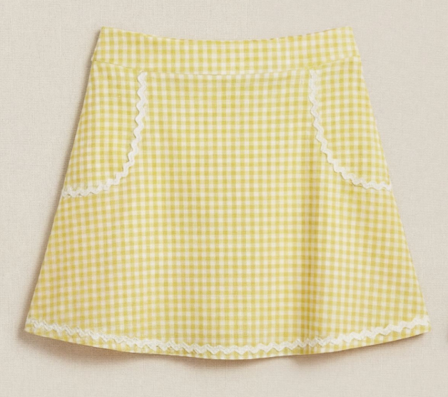 Yellow and white gingham skirt with white trim shown on a beige background