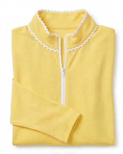 Yellow long sleeve polo top with white ric rac collar trim folded and set against a flat white background