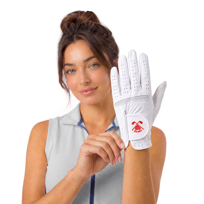 A woman wearing a white golf glove with a red logo, holding it up against a clean white background.