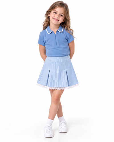 A young girl modeling a light blue polo shirt with a white collar and a matching light blue pleated skirt with white lace trim, paired with white socks and sneakers, on a solid white background.