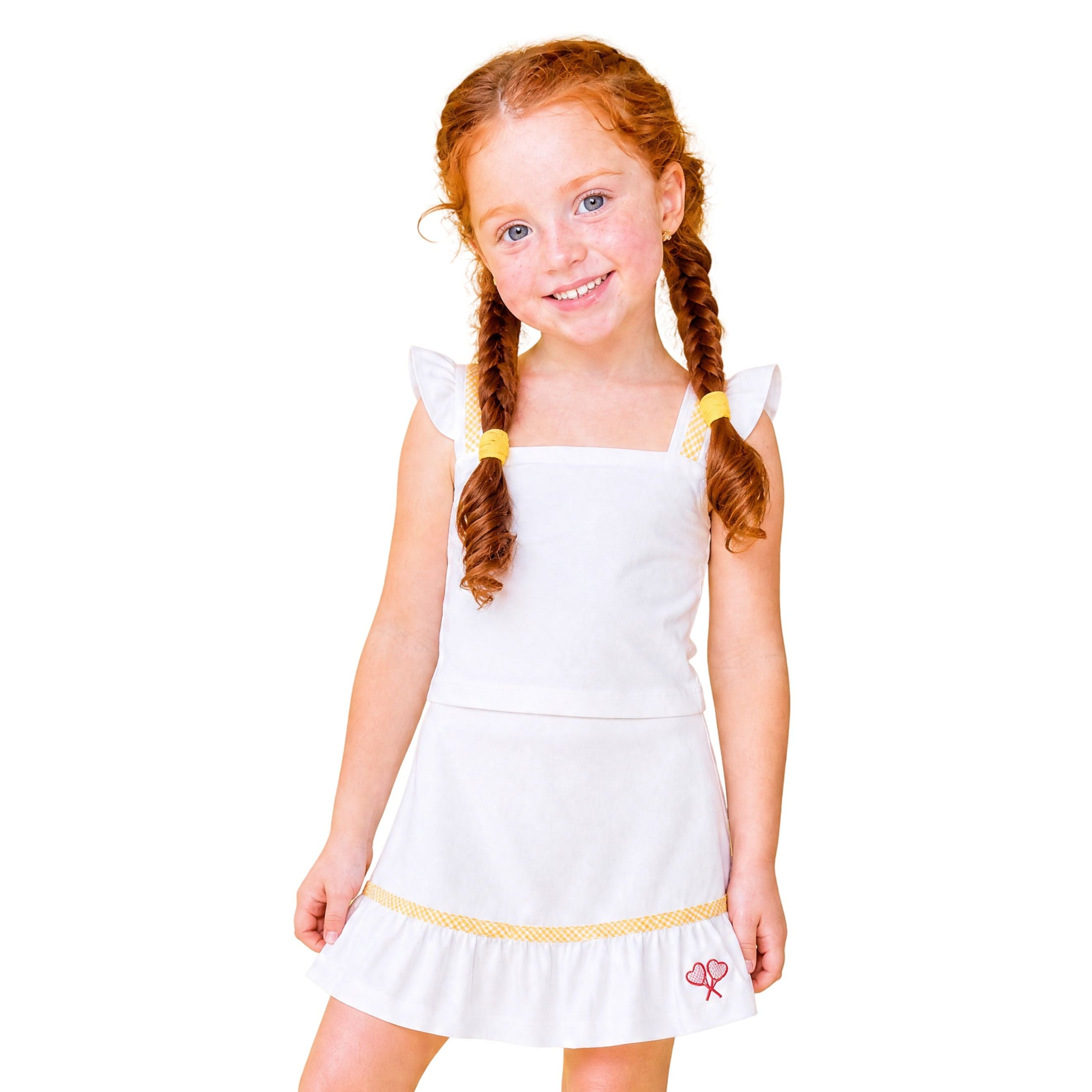 Young girl wearing a white dress with yellow trim on a white background