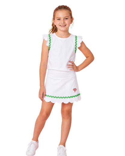 Young girl wearing a white dress with green trim on a white background
