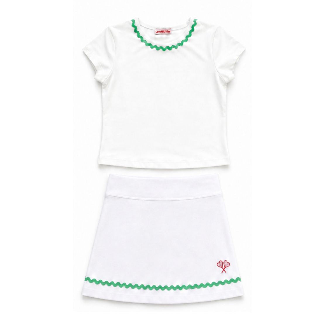 White top and skirt set with green trim on a white background