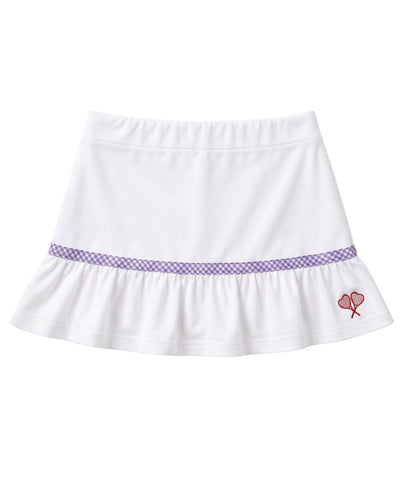 A white ruffled skirt with a purple gingham pattern band around the waist and a small red embroidered heart tennis rackets crossed motif on the lower right side, shown against a plain white background.