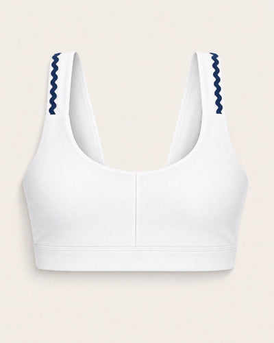 White sports bra with blue accents on a beige background