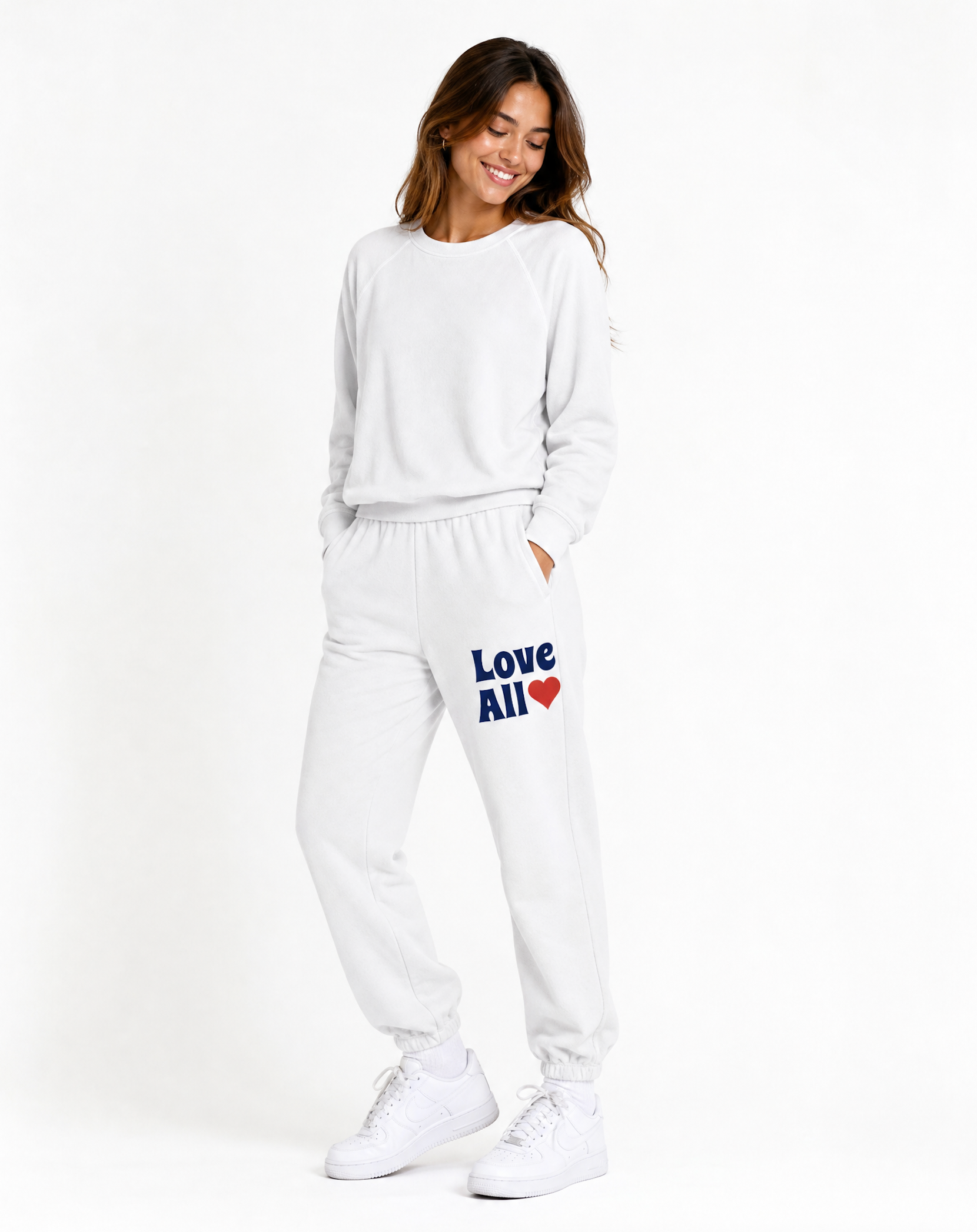 Woman wearing a white tracksuit with 'Love All' text on a white background