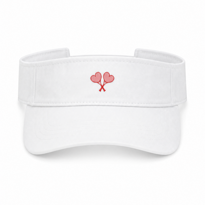 A white visor hat featuring a small embroidered design of two pink heart tennis rackets crossed on the front center, set against a plain white background.