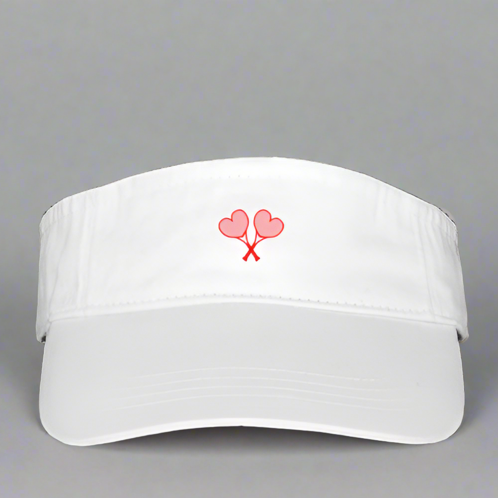White visor with pink heart design on a gray background