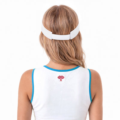 A woman viewed from behind wearing a white visor-style headband and a white sleeveless top with blue trim and a small red heart graphic on the back, against a plain white background.