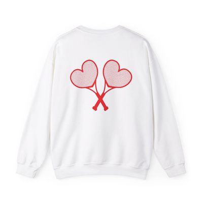 A white sweatshirt with red heart tennis rackets crossed on the back set against a white background