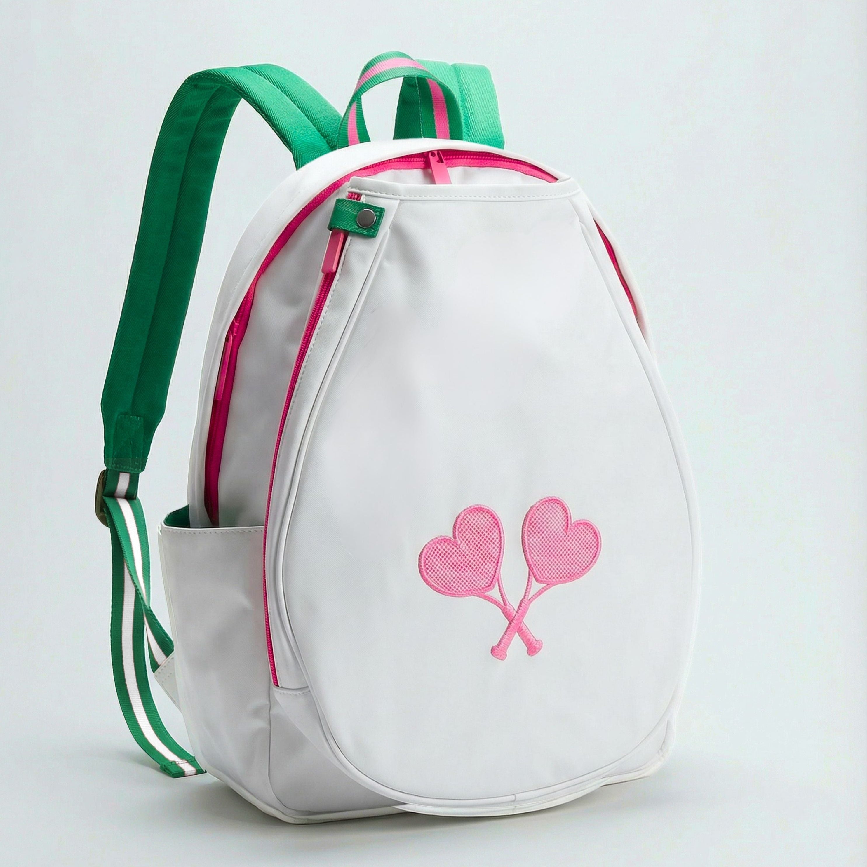 White backpack with green straps and pink heart design on a light gray background