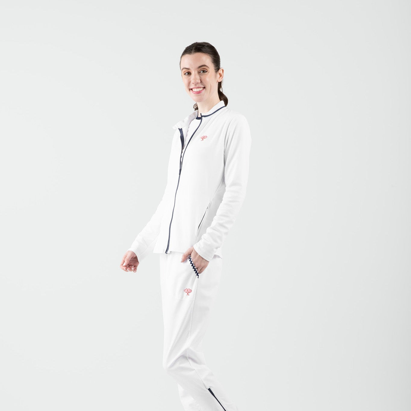 Person wearing a white and navy tennis outfit on a plain background
