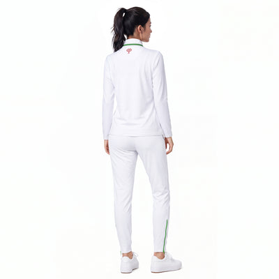 A woman shown from the back wearing a white athletic tracksuit with a green and pink logo on the collar, white pants with a green stripe, and white sneakers, set against a plain white background.