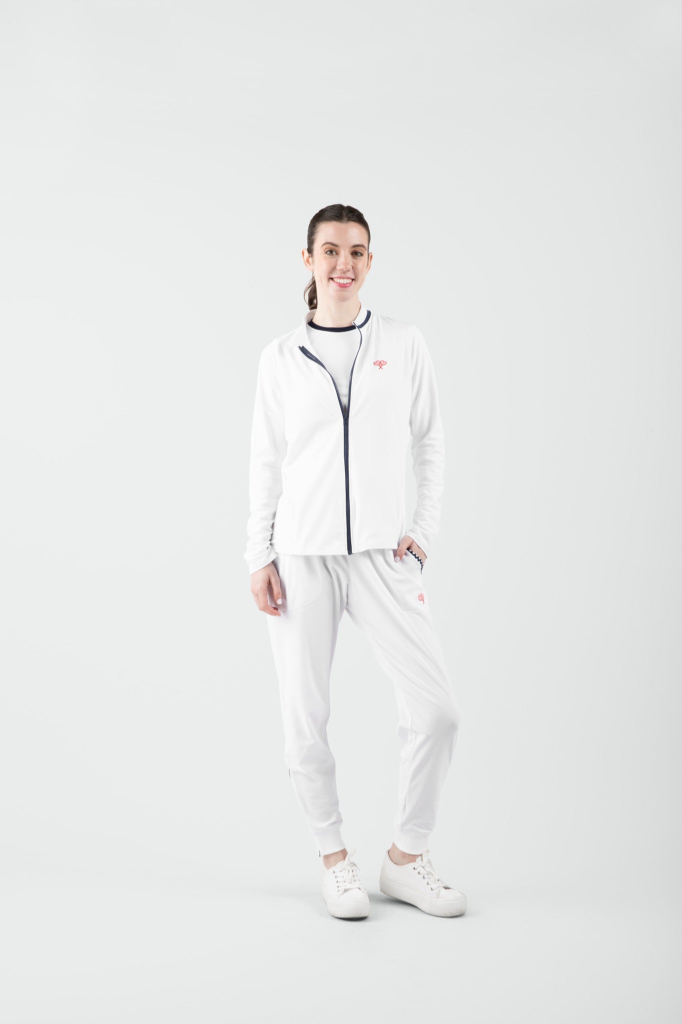 Person wearing a white outfit with a logo on a light gray background