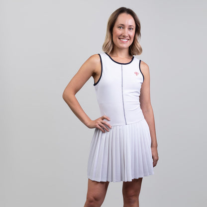 Woman wearing a white dress with navy trim on a gray background