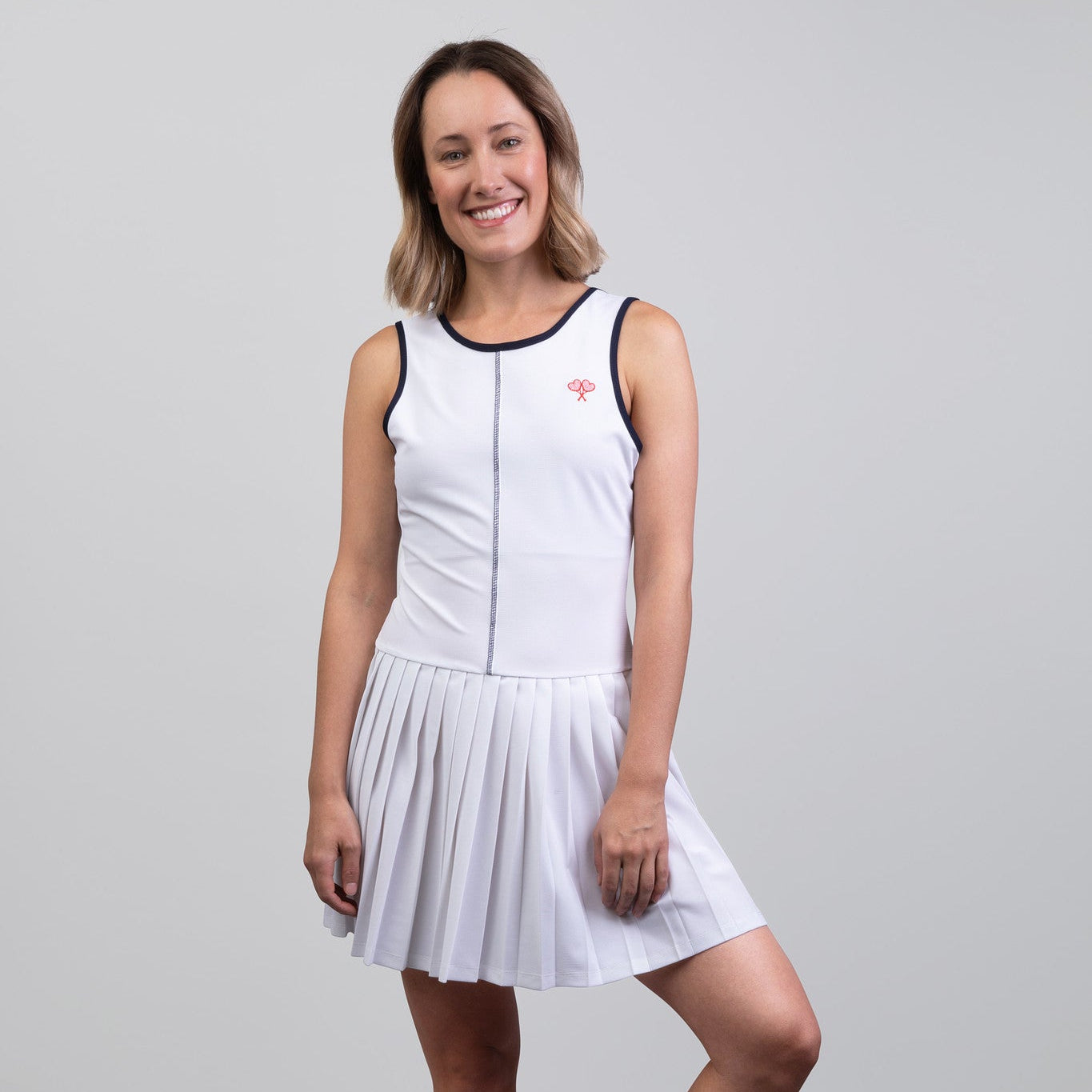 Woman wearing a white tennis dress on a gray background