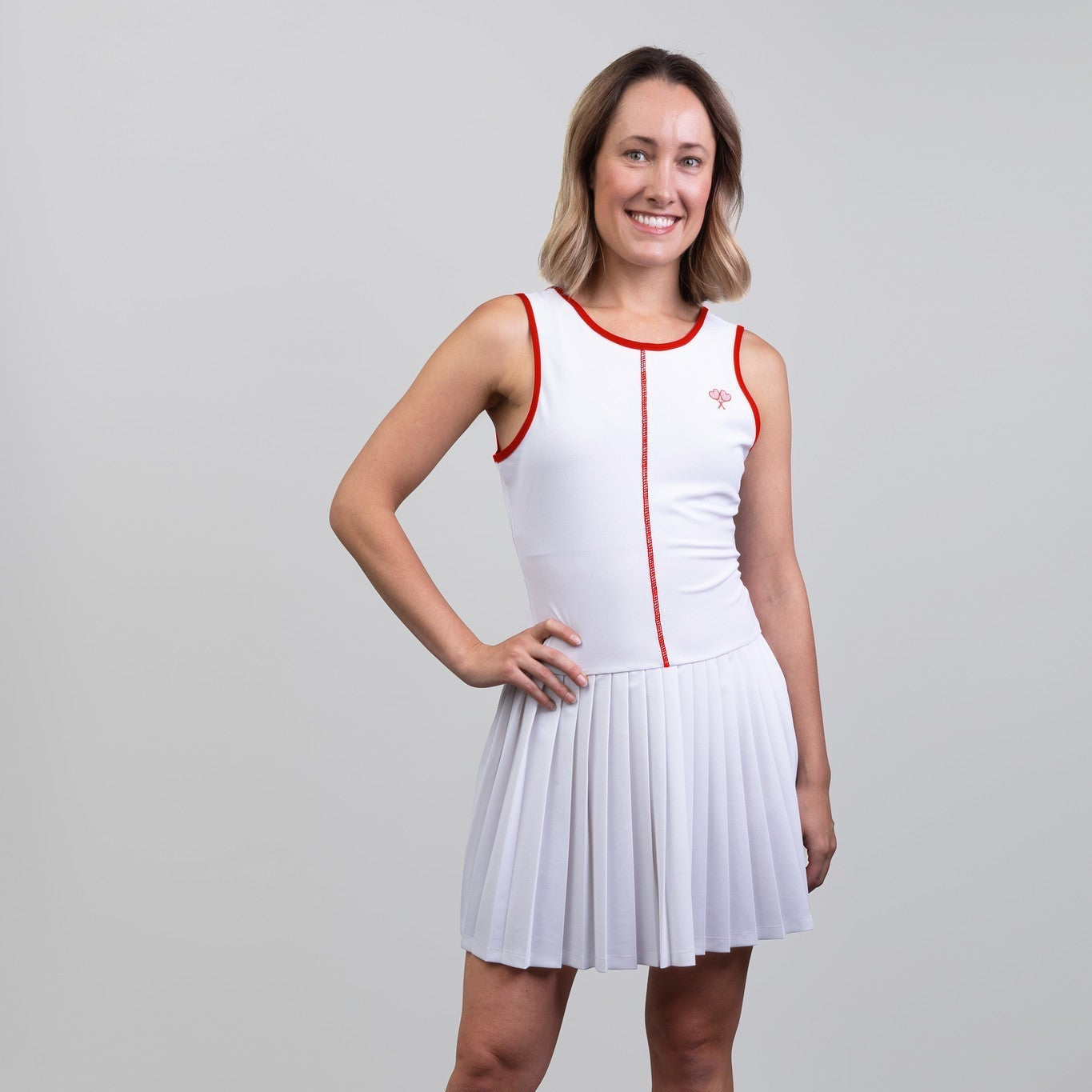 Woman wearing a white dress with red accents on a gray background