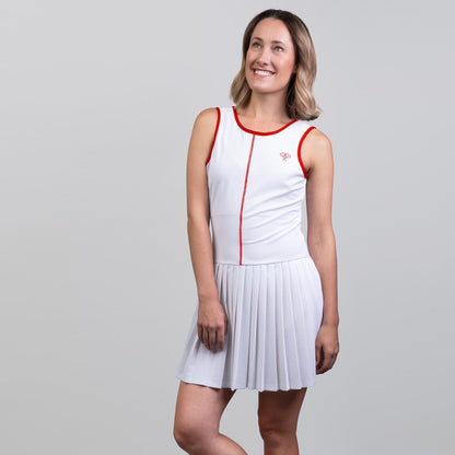 Woman wearing a white dress with red accents on a gray background