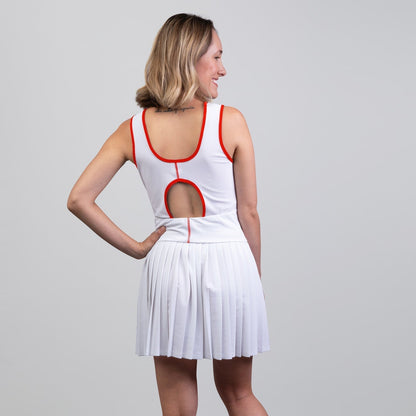 Woman wearing a white dress with red accents on a plain background