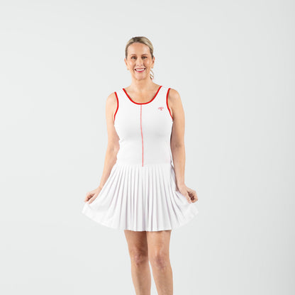 Woman wearing a white tennis dress with red accents on a white background