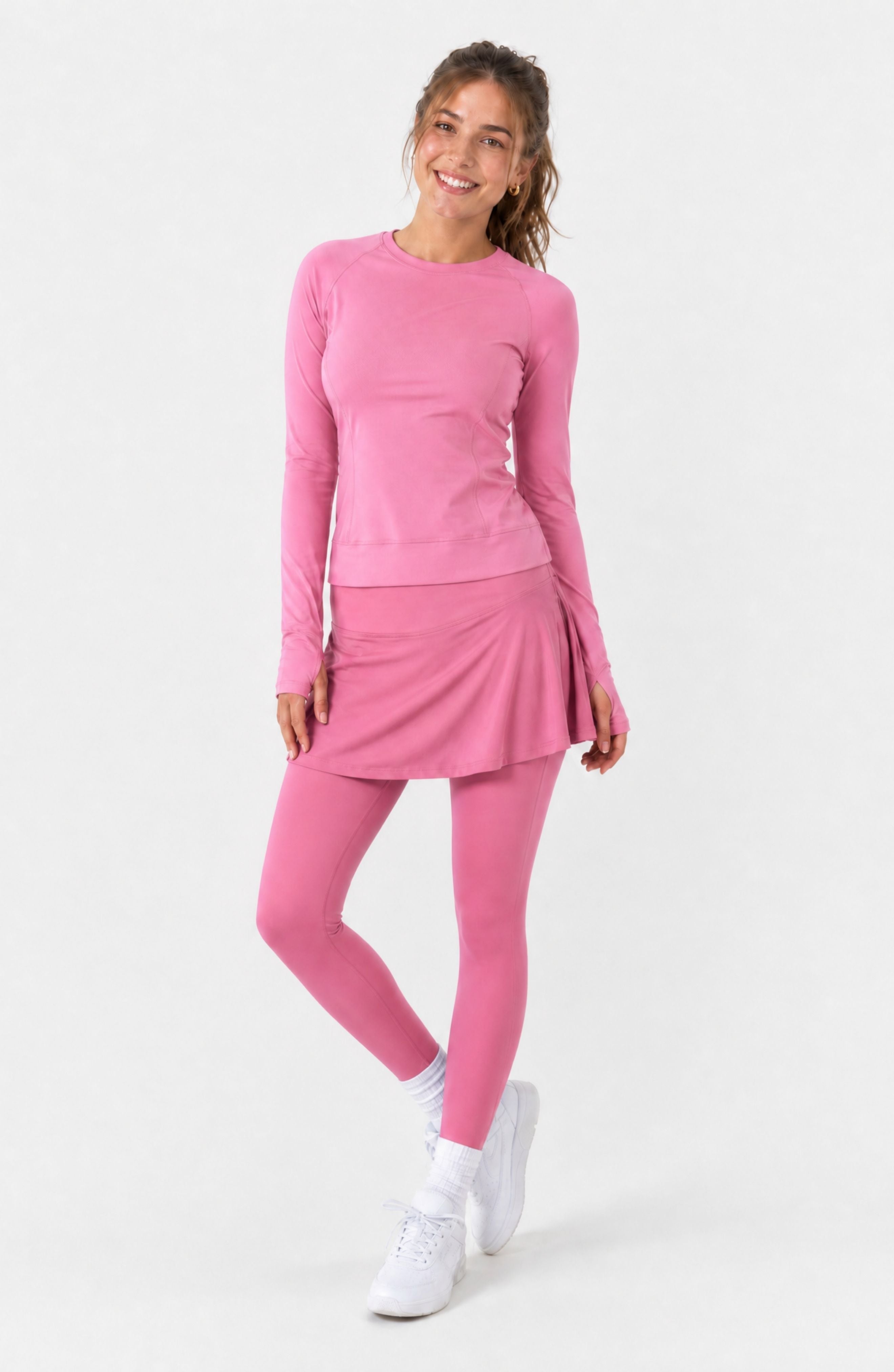 Woman wearing a pink athletic outfit on a white background