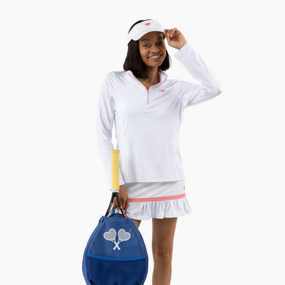 Person in tennis attire holding a blue racket bag on a white background