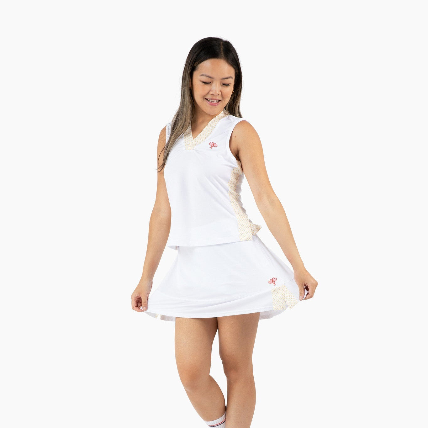 Woman wearing a white tennis outfit on a white background