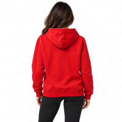 A woman viewed from the back wearing a bright red pullover hoodie and black pants against a plain white studio background.