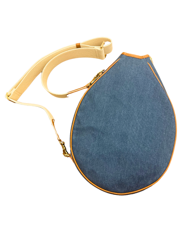 A denim teardrop-shaped shoulder bag with a cream-colored adjustable strap and gold-tone hardware, shown on a plain white background.