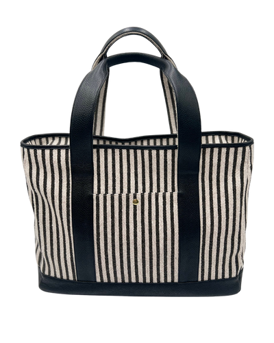 A striped tote bag with black leather handles and trim, featuring vertical black and cream stripes on a woven canvas body, shown against a plain white background.