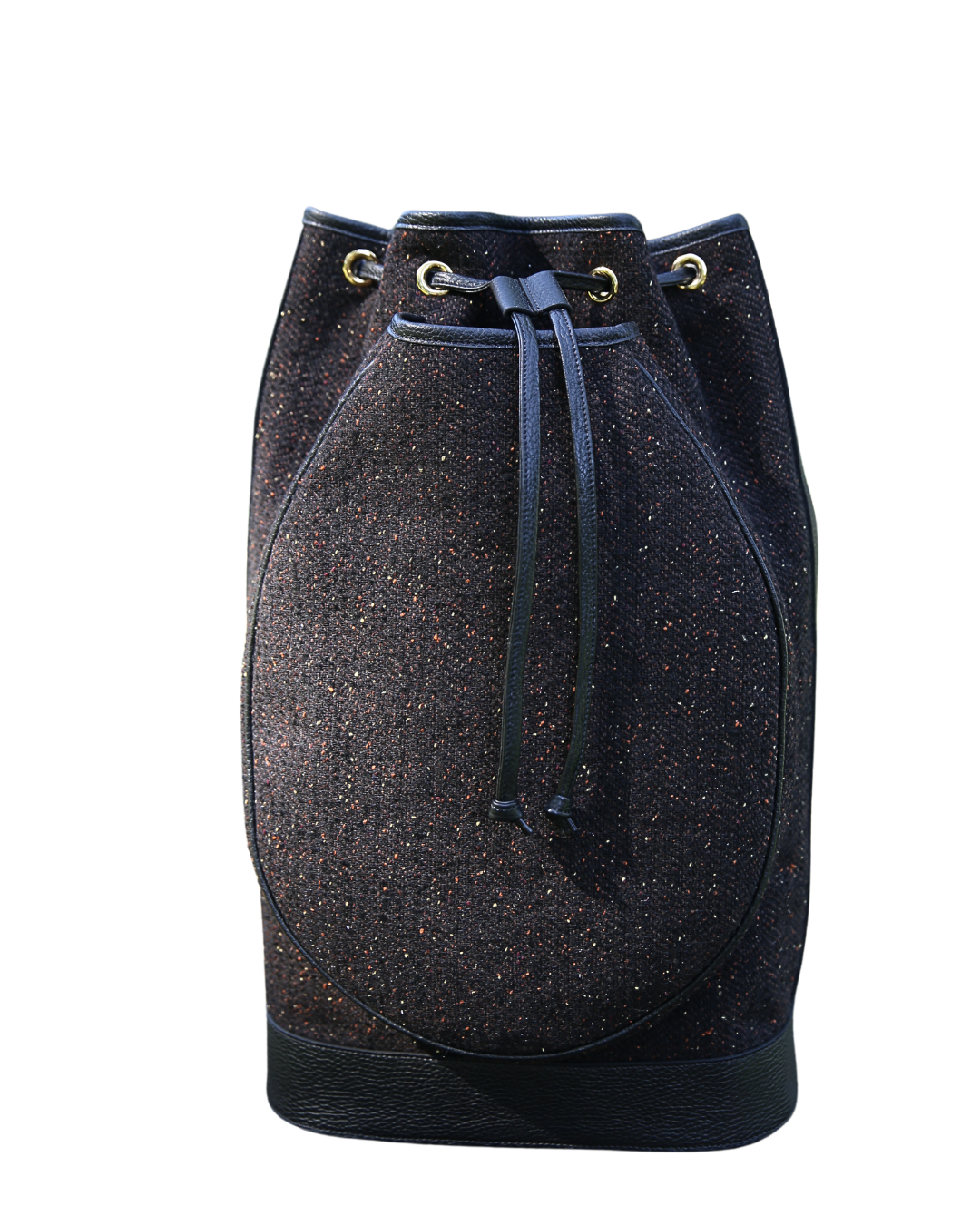 A dark blue and black speckled bucket bag with a drawstring closure and brass eyelets, shown against a plain white background.