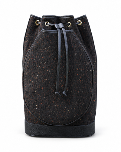 A black speckled tweed bucket bag with a dark drawstring and gold-tone eyelets, shown against a plain white background.