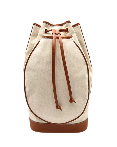 A canvas bucket bag in beige with brown leather trim, drawstring closure, and a brown base, shown against a plain white background.